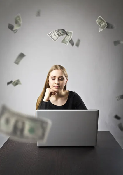 Dizüstü bilgisayar ile genç bir kadın. Genç kadın ve düşen Doları banknot — Stok fotoğraf