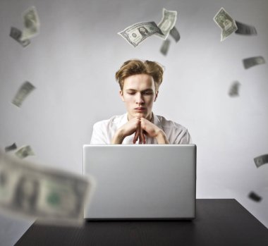 Dizüstü bilgisayar ile genç adam. Genç bir işçi ve düşen Euro banknot.