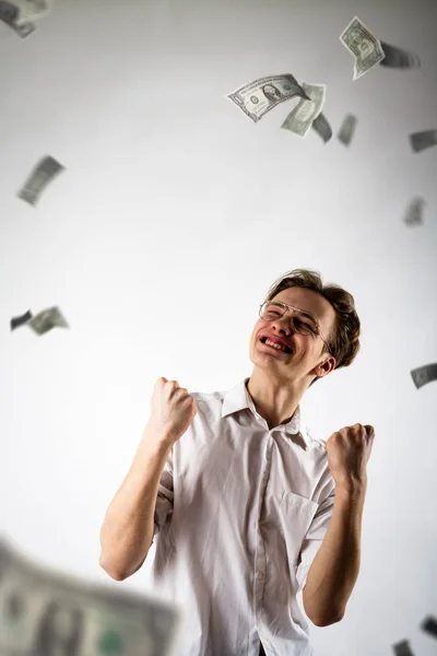 Un jeune homme en blanc se réjouit. Homme en blanc et dollars . — Photo