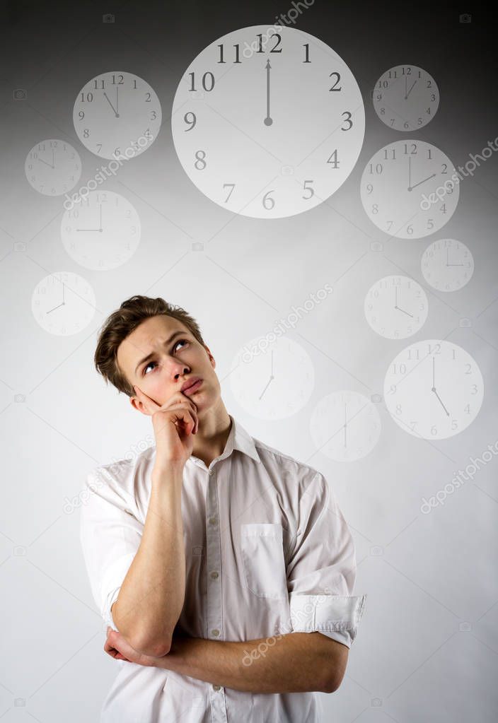 Young man in white and clock. Time is passing. 