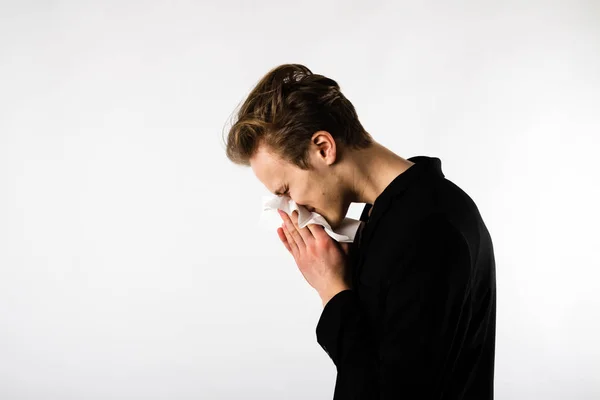 Junger Mann in Schwarz niest — Stockfoto