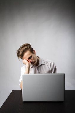 Dizüstü bilgisayar ile genç adam. Fazla mesai.