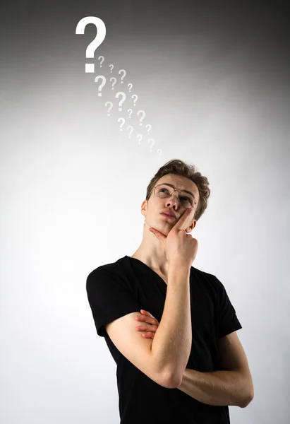 Young man is full of doubts and hesitation. Young man and Questi — Stock Photo, Image