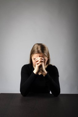 Genç kadın tesbih boncuk ile dua ediyor.