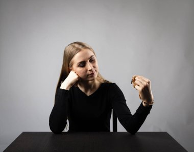 Genç kadın tesbih boncuk ile dua ediyor.