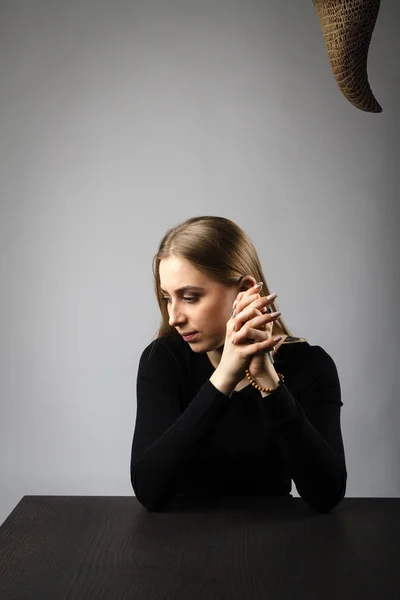 Junge Frau betet mit Rosenkranzperlen. Gebet und Versuchung. — Stockfoto