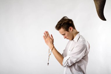 Genç adam tespih ile dua ediyor. Dua ve ayartma..