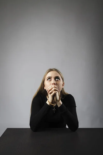 Mujer joven está rezando con rosarios . — Foto de Stock