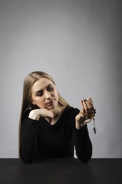 Junge Frau betet mit Rosenkranzperlen. — Stockfoto