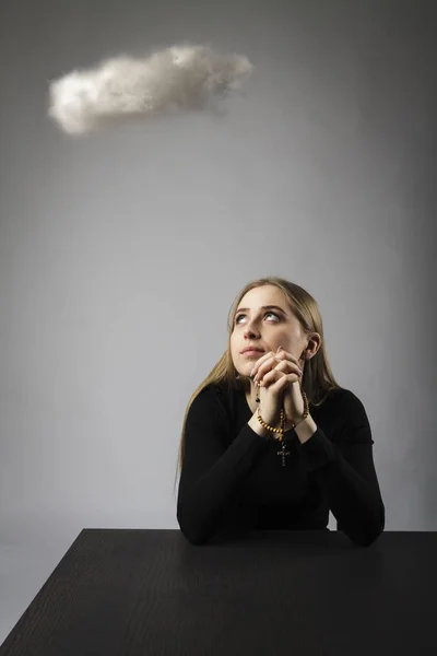 Young woman is praying with rosary beads and cloud. — Stock Photo, Image