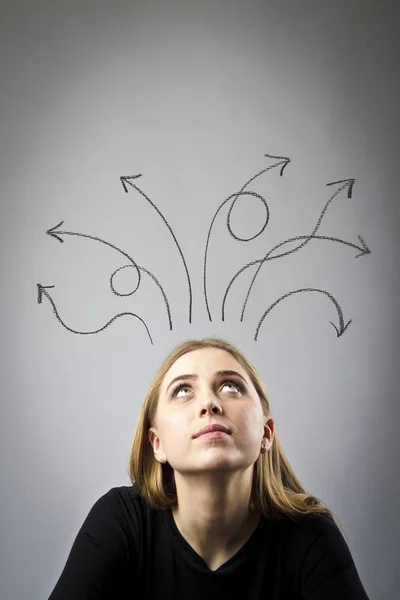 Frustrated young woman in thoughts. Arrows over her head. — Stock Photo, Image