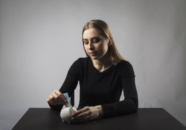 Siyah ve domuz kumbarasında genç bir kadın