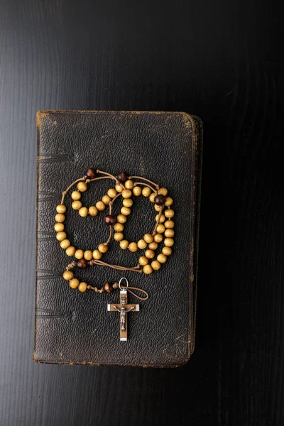 Rosary beads and prayer book on dark background. — Stock Photo, Image