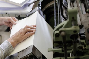 Tipografide ipliklerle kitap sayfalarını dikme makinası.