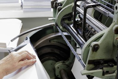 Tipografide ipliklerle kitap sayfalarını dikme makinası.