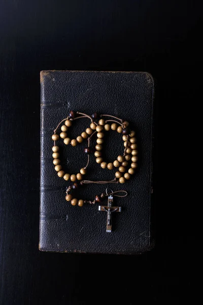 Rosário contas e livro de orações sobre fundo escuro . — Fotografia de Stock