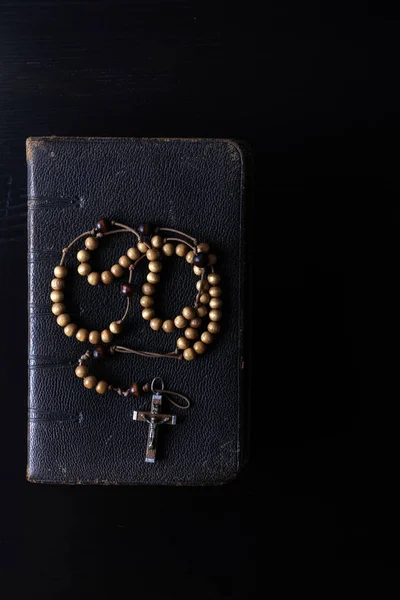 Rosary beads and prayer book on dark background. — Stock Photo, Image