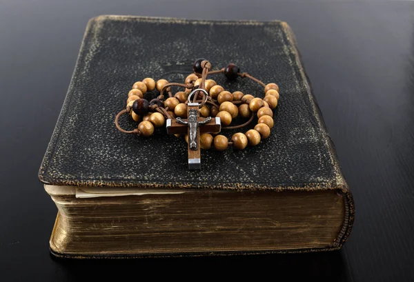 Rosary beads and prayer book on dark background. — Stock Photo, Image