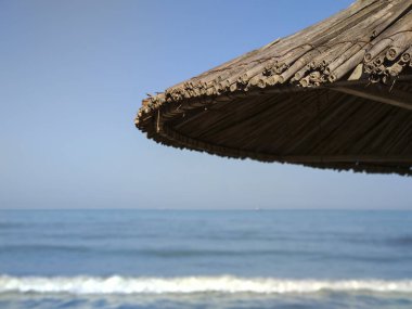 Mavi gökyüzüne karşı saman şemsiyeler. Şemsiye. 