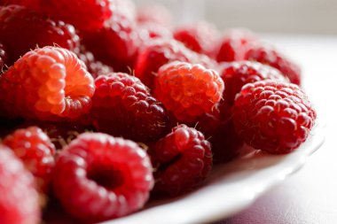 Beyaz bir tabak içinde ahududu