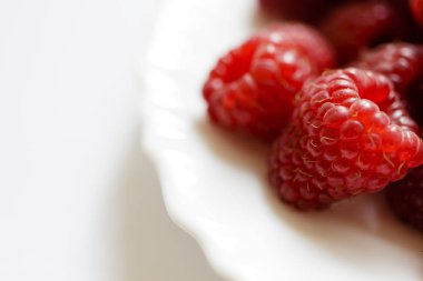 Beyaz bir tabak içinde ahududu