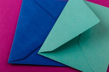 Mor arka planda renkli zarflar. Posta zarfları masanın üstünde..