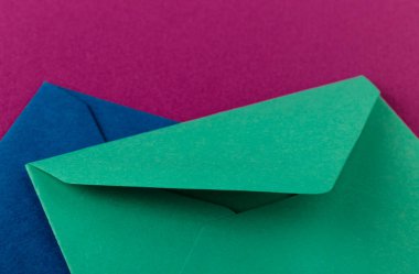 Mor arka planda renkli zarflar. Posta zarfları masanın üstünde..