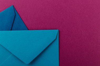 Mor arka planda renkli zarflar. Posta zarfları masanın üstünde..