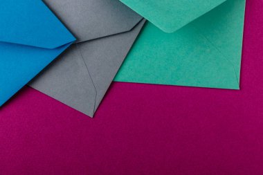 Mor arka planda renkli zarflar. Posta zarfları masanın üstünde..