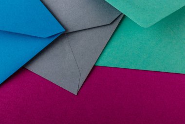 Mor arka planda renkli zarflar. Posta zarfları masanın üstünde..