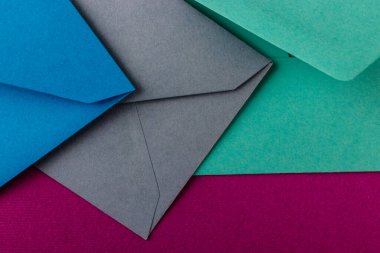 Mor arka planda renkli zarflar. Posta zarfları masanın üstünde..