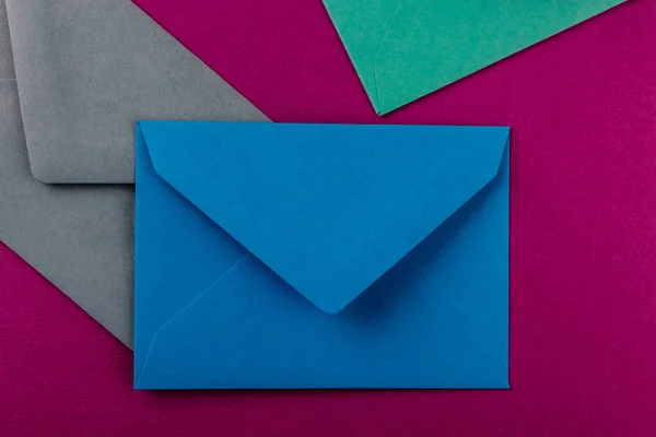 紫色背景上的彩色信封 桌上的邮包 — 图库照片