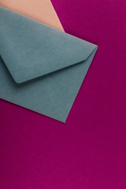 Mor arka planda renkli zarflar. Posta zarfları masanın üstünde..