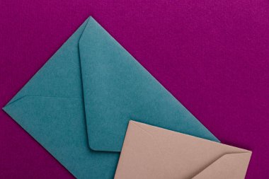 Mor arka planda renkli zarflar. Posta zarfları masanın üstünde..