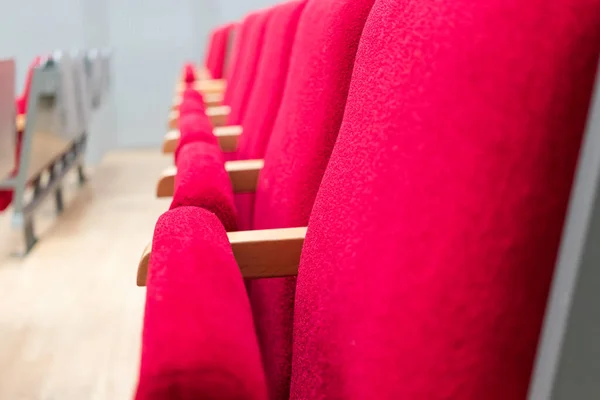 Rows of empty chairs in the conference room close-up. Lecture hall. Red chairs.