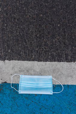 Asfaltta tıbbi koruyucu maske. Yere atılmış tıbbi maske. Coronavirüs salgını kavramı.