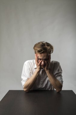 Yorgun genç adam. Hayal kırıklığı, fazla mesai ve yorgunluk konsepti. Kendimi kötü hissediyorum. Kötü durumda ve sağlıksız..