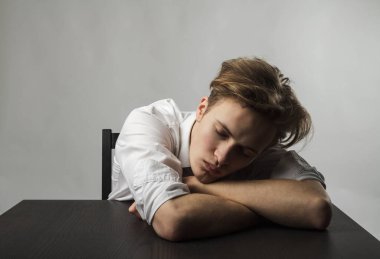 Yorgun genç adam. Hayal kırıklığı, fazla mesai ve yorgunluk konsepti. Kendimi kötü hissediyorum. Kötü durumda ve sağlıksız..