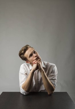 Beyazlı genç adam şüphe ve tereddütlerle doludur. Şüphe ve rüya kavramı. Hayalperest.