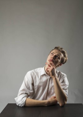 Beyazlı genç adam şüphe ve tereddütlerle doludur. Şüphe ve hayal konsepti.