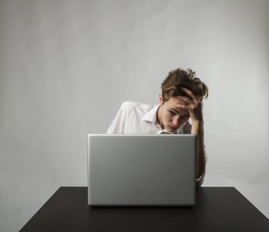 Laptoplu sinirli genç adam. Beyazlı adam baş ağrısından muzdarip. İfadeler, duygular ve ruh halleri.