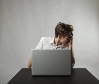 Laptoplu sinirli genç adam. Beyazlı adam baş ağrısından muzdarip. İfadeler, duygular ve ruh halleri.