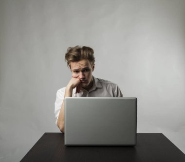 Laptoplu sinirli genç adam. İfadeler, duygular ve ruh halleri. Öğrenme ve evde çalışma.