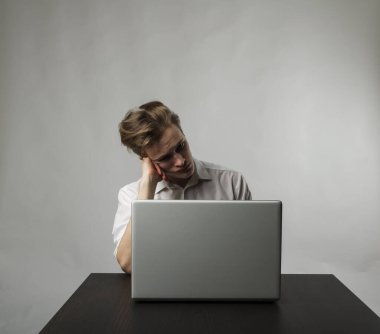 Laptoplu sinirli genç adam. İfadeler, duygular ve ruh halleri. Öğrenme ve evde çalışma.