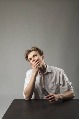 Beyazlı genç adam akıllı telefon kullanıyor. Hayalperest.