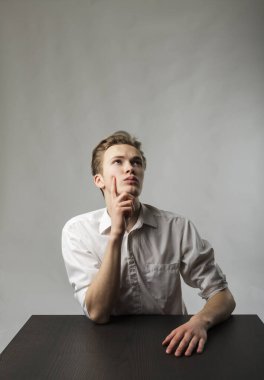 Beyazlı genç adam şüphe ve tereddütlerle doludur. Şüphe ve hayal konsepti.