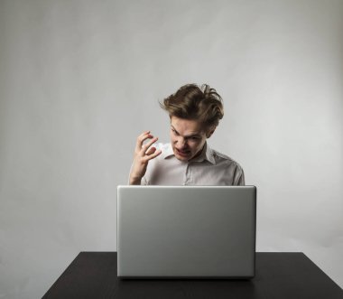Beyazlı kızgın adam. Laptopla hayal kırıklığına uğramış ve hayal kırıklığına uğramış genç bir adam. İfadeler, duygular ve ruh halleri.