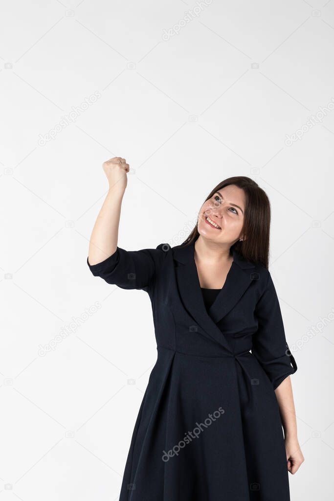 Rejoicing young woman in blue on bright background. Success and winner concept.