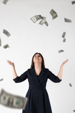 Sevinçliyim. Mavi elbiseli kadın ve düşen dolar banknotları. Başarı, para birimi ve piyango konsepti
