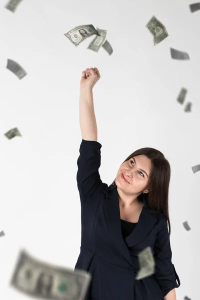 Rejoicing. Woman in blue and falling dollar banknotes. Success, currency and lottery concept.